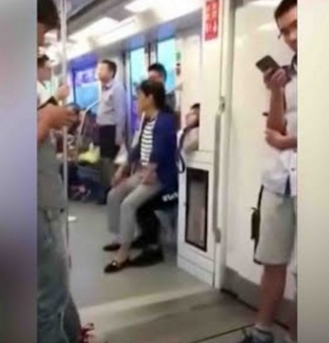 中国 初老の女性が地下鉄で席を譲らない事に腹を立て男性の膝の上に座る